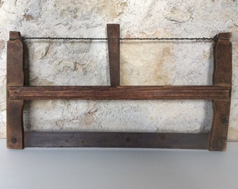 Antique bow saw, a rustic French wooden frame saw