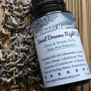 May include: A small, clear glass bottle with a black cap, labeled "Lokahi Hawaii Sweet Dreams Night Oil" and containing essential oils for sleep and relaxation. The bottle is sitting on a woven mat with dried lavender flowers.