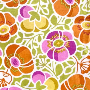 May include: A fabric with a repeating pattern of stylized flowers in shades of orange, pink, and yellow on a green background.