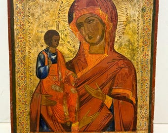 May include: An antique icon painting depicting the Virgin Mary and baby Jesus. The icon is painted on wood and features a gold background with intricate details. The Virgin Mary is wearing a red robe and a blue veil, while Jesus is wearing a red robe. The icon is framed in a simple wooden frame.