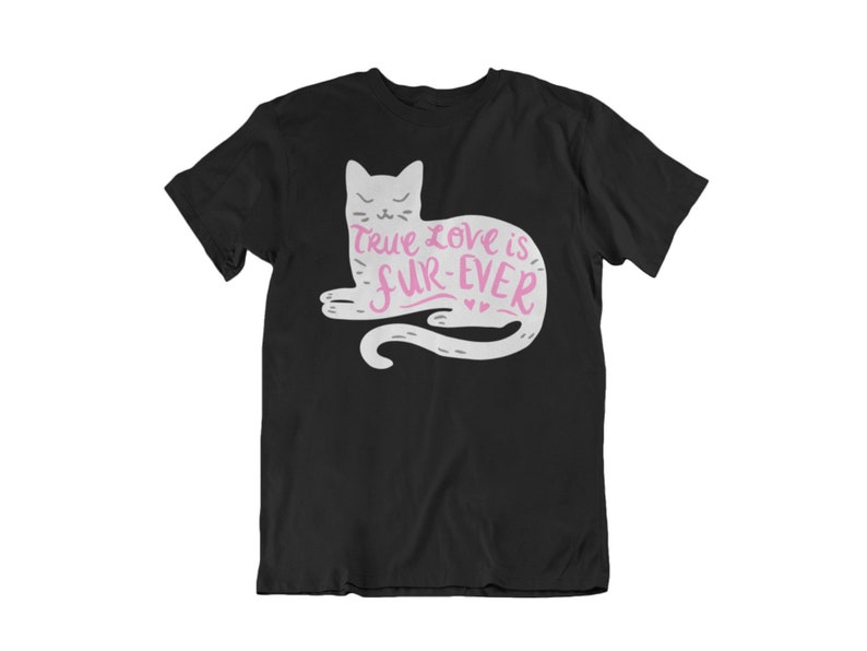May include: Black t-shirt featuring a white cat illustration with the text "True love is fur-ever" in pink. The cat design includes a tail and small hearts. The shirt is a classic crew neck style.