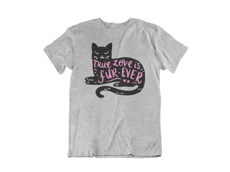 May include: A light gray t-shirt featuring a black cat illustration with the text "True love is fur-ever" in pink. The cat is lying down with its tail curled. The shirt is made of a soft material.