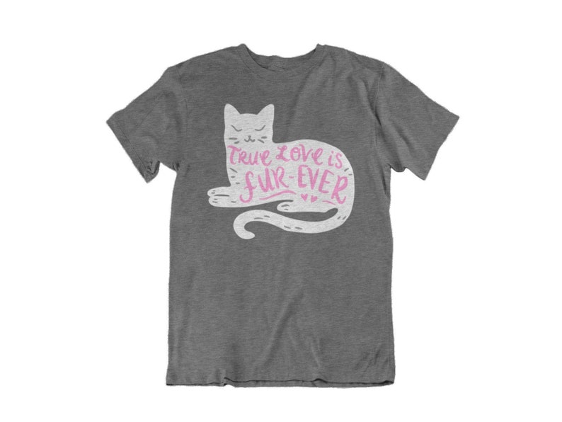 May include: A heather gray t-shirt featuring a white cat illustration with the text "True Love is Fur-Ever" in pink. The cat is lying down with its tail curled. The shirt is a casual wear item.