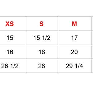 May include: A white chart with black text and red size labels. The chart displays measurements in inches for sleeve length, body width, and body length across sizes XS to XL. Measurements range from 15 inches to 31 1/4 inches.