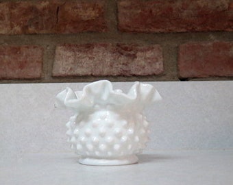 Könnte beinhalten: Eine weiße Milchglas-Blumenvase mit einem gekräuselten Rand und einer strukturierten, unebenen Oberfläche.