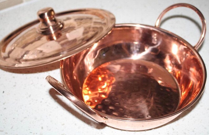 May include: A copper serving dish with a lid and two handles. The dish has a hammered finish and is perfect for serving small dishes.