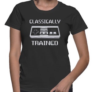 May include: Black t-shirt with white text that reads "Classically Trained" and a pixelated image of a classic video game controller.