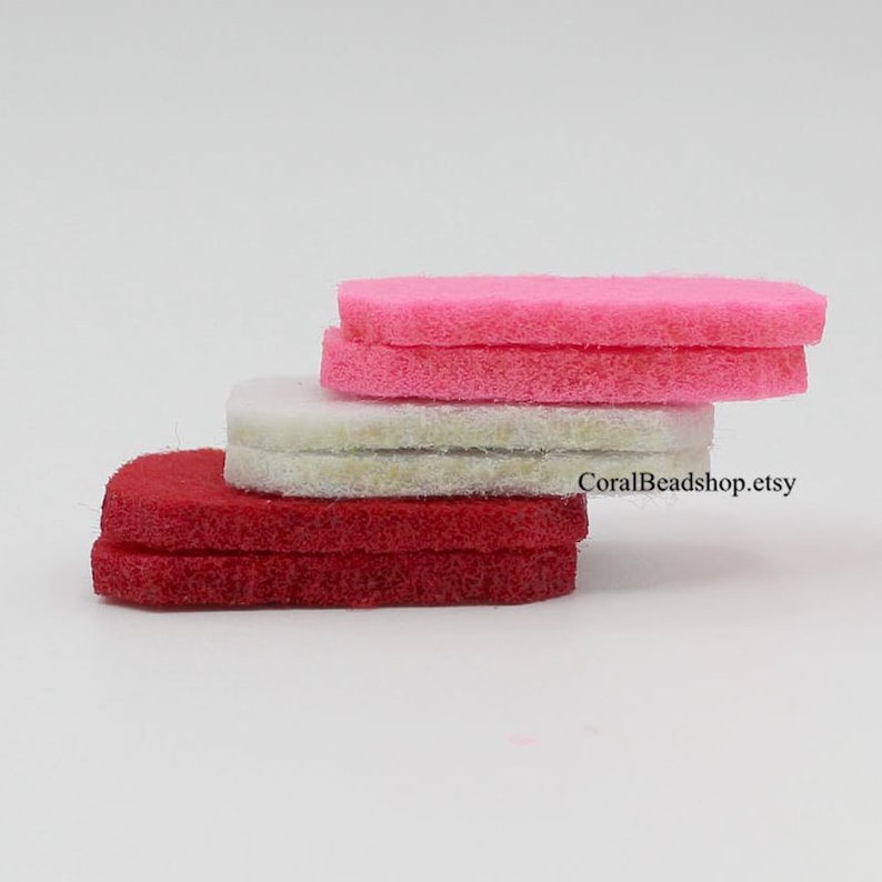 May include: A stack of six flat, rectangular felt pieces arranged in three colour-coded pairs. The top pair is bright pink, the middle pair is off-white, and the bottom pair is deep red. The text CoralBeadshop.etsy is visible on the side.
