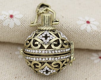 May include: A gold-toned metal charm with a filigree design and clear rhinestones. The charm is shaped like a sphere and has a small loop at the top for attaching to a necklace or bracelet.