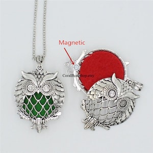 May include: Silver owl pendant necklace with a green glass insert. The back of the pendant opens to reveal a red felt interior and a magnetic closure. The text "CoralBeadshop.etsy" is visible on the back of the pendant.