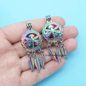 May include: Two iridescent rainbow coloured metal dreamcatcher charms with a dragonfly design and dangling feathers.