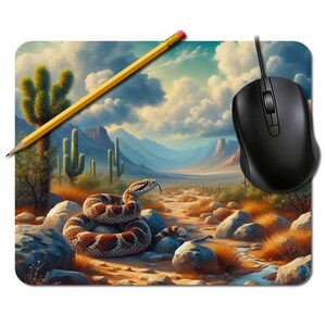 Può includere: Un tappetino per mouse rettangolare con un paesaggio desertico, un serpente arrotolato, cactus e montagne sotto un cielo nuvoloso. Una matita gialla e un mouse per computer nero sono sopra.