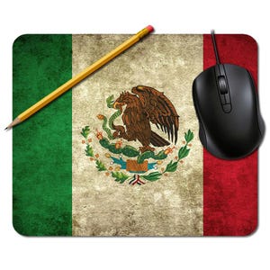 May include: Mouse mat with the Mexican flag design, showing green, white, and red stripes and the coat of arms. The design has a distressed, vintage appearance. A black computer mouse and a yellow pencil are on the mat.