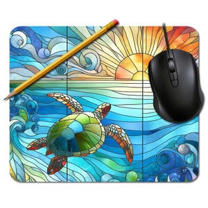 May include: A rectangular mouse mat with a stained-glass design of a sea turtle swimming in the ocean. The design includes a yellow sun, blue waves, and a black computer mouse. A yellow pencil rests on the mat.