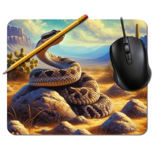 May include: A mouse mat with a coiled rattlesnake on a rock in a desert scene. A yellow pencil rests on the snake. A black computer mouse is on the right. The background shows mountains and a cloudy sky. The image has a painted style.