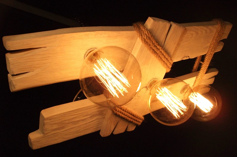 Puede incluir: Una l&aacute;mpara de madera r&uacute;stica con cuatro bombillas de filamento expuestas. La l&aacute;mpara est&aacute; hecha de madera recuperada y presenta un dise&ntilde;o de cuerda.