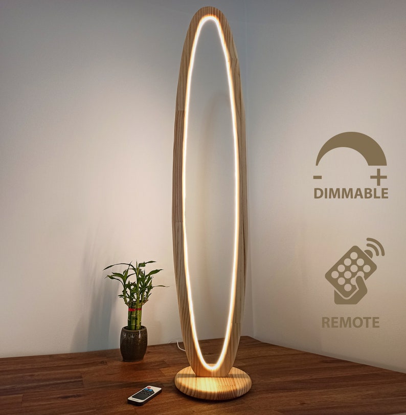 May include: A tall, wooden floor lamp with a warm white oval light. The lamp is dimmable and comes with a remote control.