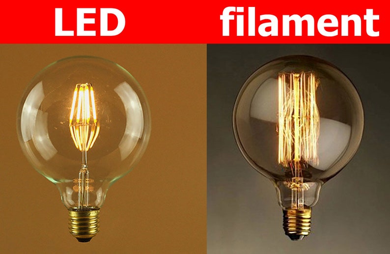 Puede incluir: Dos bombillas, una con una bombilla de vidrio transparente y un filamento LED, y la otra con una bombilla de vidrio esmerilado y un filamento tradicional. El texto "LED" est&aacute; sobre la primera bombilla y "filament" sobre la segunda.