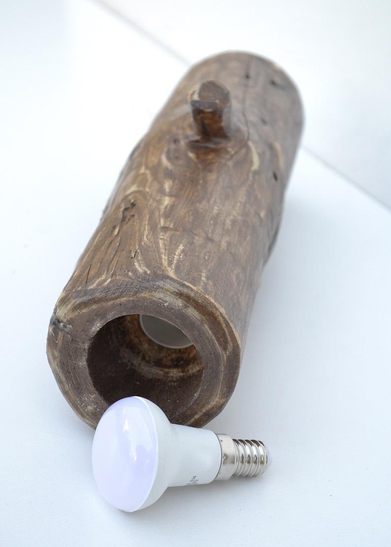 May include: A wooden log lamp base with a hole in the center for a light bulb. A white LED light bulb is shown next to the log base.