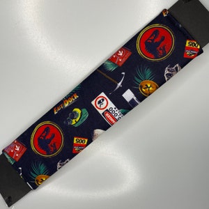 Jurassic Park movie dinosaur Seatbelt cover pad with popper fastening.