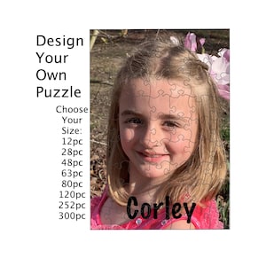 May include: A custom photo puzzle featuring a portrait of a young person with blonde hair wearing a pink top. The text reads Design Your Own Puzzle, Choose Your Size, 12pc, 28pc, 48pc, 63pc, 80pc, 120pc, 252pc, 300pc, and the name Corley.