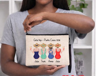Peut inclure: Une trousse de maquillage en toile beige avec une fermeture éclair noire et une dragonne. Le sac présente une illustration de quatre femmes en maillots de bain et chapeaux de soleil, tenant des cocktails. Le texte sur le sac indique "Girls Trip - Punta Cana 2026" et les noms "Julie, Trish, Annie, Julie".