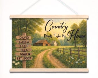 May include: A hanging wall sign featuring a rural landscape with a dirt path, a barn, and a wooden signpost listing the names David, Carla, Cole, Ella, Max, and Est. 2007. The text Country Roads Take Me Home is printed in black script.