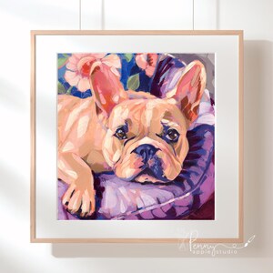 May include: A framed painting of a French Bulldog with a light brown coat, large ears, and a black nose. The dog is lying on a purple pillow with a floral background. The artwork is signed by "penny apple studio".