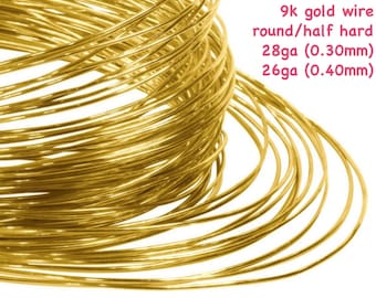 May include: A close-up of coiled 9k gold wire, round and half-hard. The image shows the wire in 28ga (0.30mm) and 26ga (0.40mm) sizes. The bright yellow gold wire is tightly wound, creating a textured appearance against a white background.