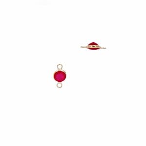 May include: Gold-tone connector with a round, red gemstone. The connector has two loops for attaching jewellery.