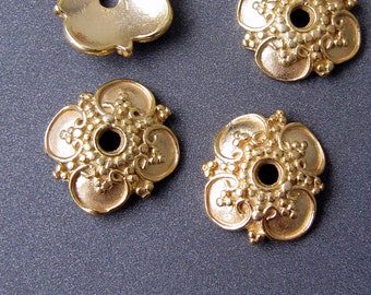 Puede incluir: Cuatro adornos decorativos de metal de color dorado con un diseño floral. Cada adorno tiene un pequeño agujero en el centro.