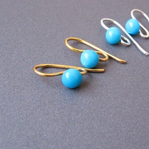 May include: Three pairs of earrings with turquoise blue beads. Two pairs are gold and one pair is silver.