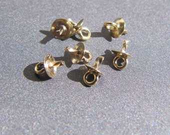 May include: Six gold-toned metal jewelry findings with a loop on one end and a flat disc on the other. These findings are used for attaching jewelry components.