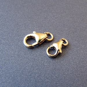 Peut inclure: Deux fermoirs à ressort en forme de griffe de homard dorés pour la fabrication de bijoux.