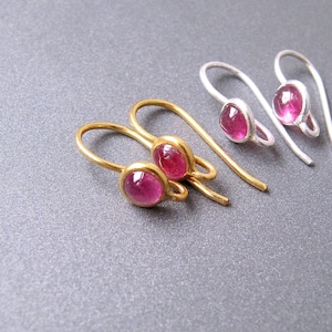 May include: Two pairs of earrings with pink gemstone accents. One pair is gold and the other is silver.
