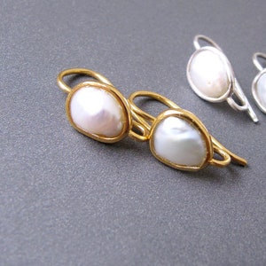 May include: Two pairs of earrings with pearl accents. One pair is gold with a larger pearl, the other is silver with a smaller pearl.