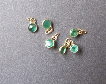 Puede incluir: Seis abalorios de piedra preciosa verde con engastes de oro. Los abalorios son de forma ovalada y tienen un bucle en la parte superior para sujetarlos a un collar o pulsera.