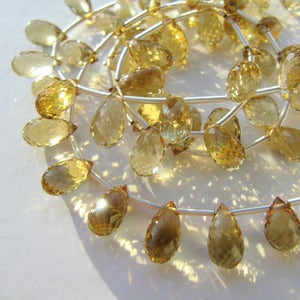 Peut inclure: Un brin de perles de pierres précieuses en forme de goutte de couleur jaune doré enfilées sur un fil d'argent.