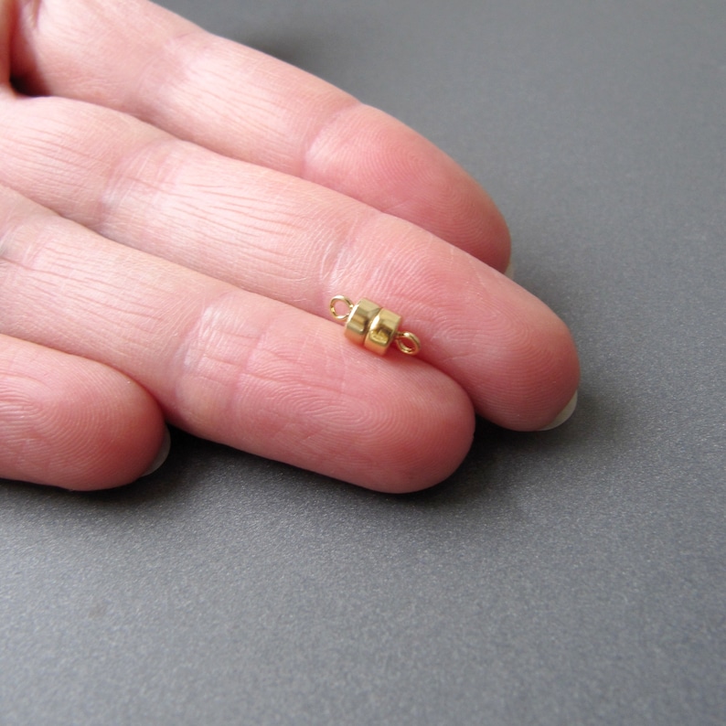 Pu&ograve; includere: Chiusura magnetica dorata per la creazione di gioielli. La chiusura &egrave; composta da due piccoli cerchi di metallo dorato collegati da un anello.