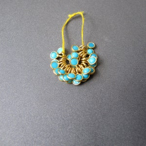 May include: A gold chain necklace with turquoise blue beads. The necklace is strung with small, round beads that are evenly spaced.