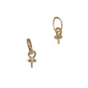 May include: Two gold-toned pearl clasps with a loop at the top and a pin at the bottom.