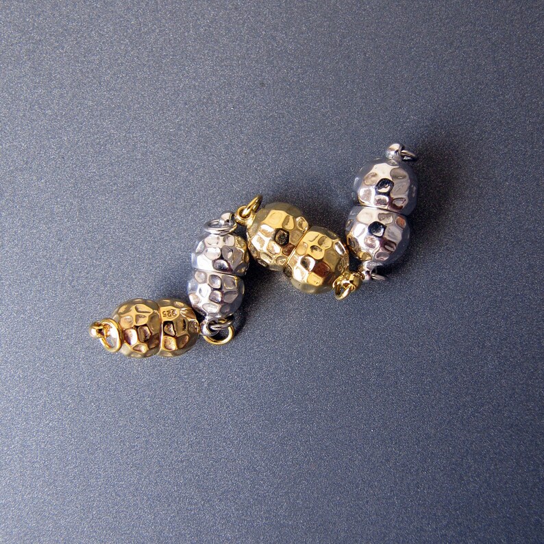Op de afbeelding: Een zilveren en gouden armband met een getextureerde, gehamerde afwerking. De armband bestaat uit afwisselende zilveren en gouden kralen.