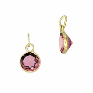 May include: Two gold pendants with pink gemstones. One pendant is viewed from the front, showing a round, faceted pink gemstone set in a gold bezel. The other pendant is viewed from the side, showing the gemstone's triangular shape.