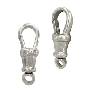 Puede incluir: Dos cierres giratorios plateados. Cada cierre tiene un gancho con resorte en la parte superior, una sección media decorativa y un pequeño anillo en la parte inferior. Diseñados para conectar artículos.