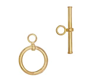 May include: A gold-colored toggle clasp set, featuring a circular ring and a bar with a small loop. The clasp is designed for jewelry making and is set against a white background.