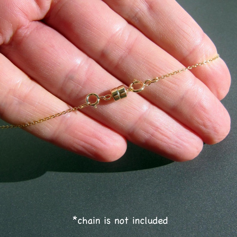 May include: Gold magnetic clasp for a necklace. The clasp is made of two round pieces of metal that connect with a magnetic force. *chain is not included*