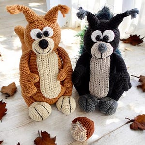 May include: Two crocheted squirrel plushies, one brown and one black, with large eyes and a brown crocheted acorn.