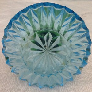 K&ouml;nnte beinhalten: Eine hellblaue Glasschale mit einem Diamantenmuster. Die Schale hat einen gewellten Rand und ist perfekt zum Servieren kleiner Snacks oder Desserts.