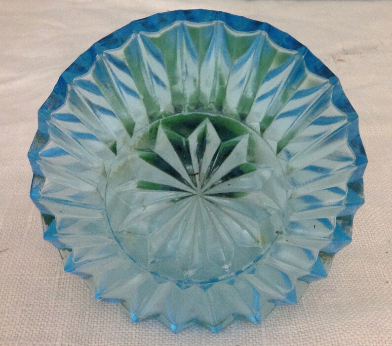 K&ouml;nnte beinhalten: Eine hellblaue Glasschale mit einem Diamantenmuster. Die Schale hat einen gewellten Rand und ist perfekt zum Servieren kleiner Snacks oder Desserts.