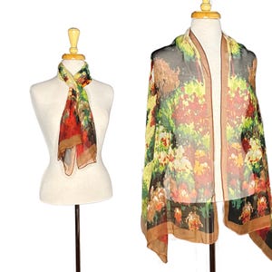 May include: Two silk scarves with floral patterns are displayed on mannequins. One scarf is draped around the neck, showcasing a red, green, and brown design. The other scarf is draped over the shoulders, featuring a similar floral pattern with a brown border.